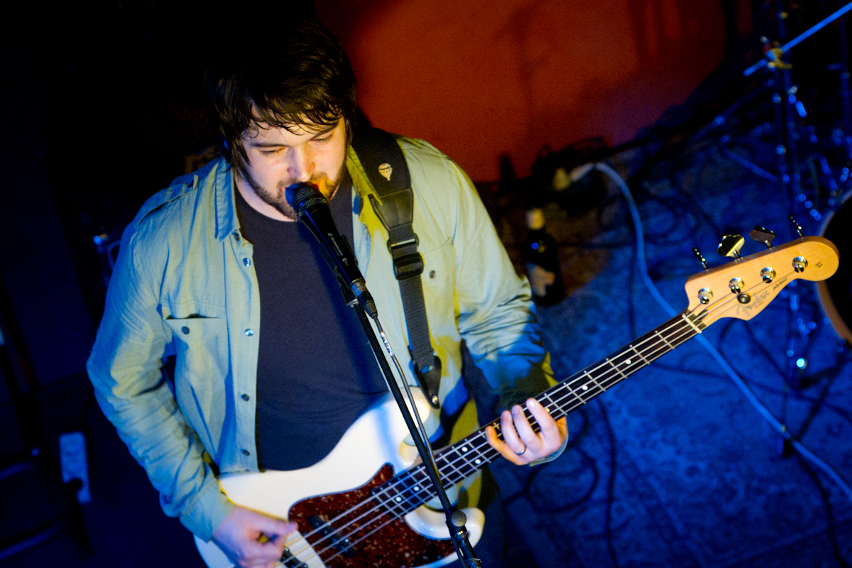 a man is holding a bass on stage
