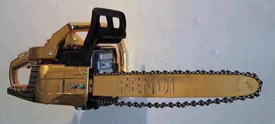 a black and gold chainsaw hanging from a wall