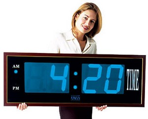 a woman holding a large black clock with the time four 20 30