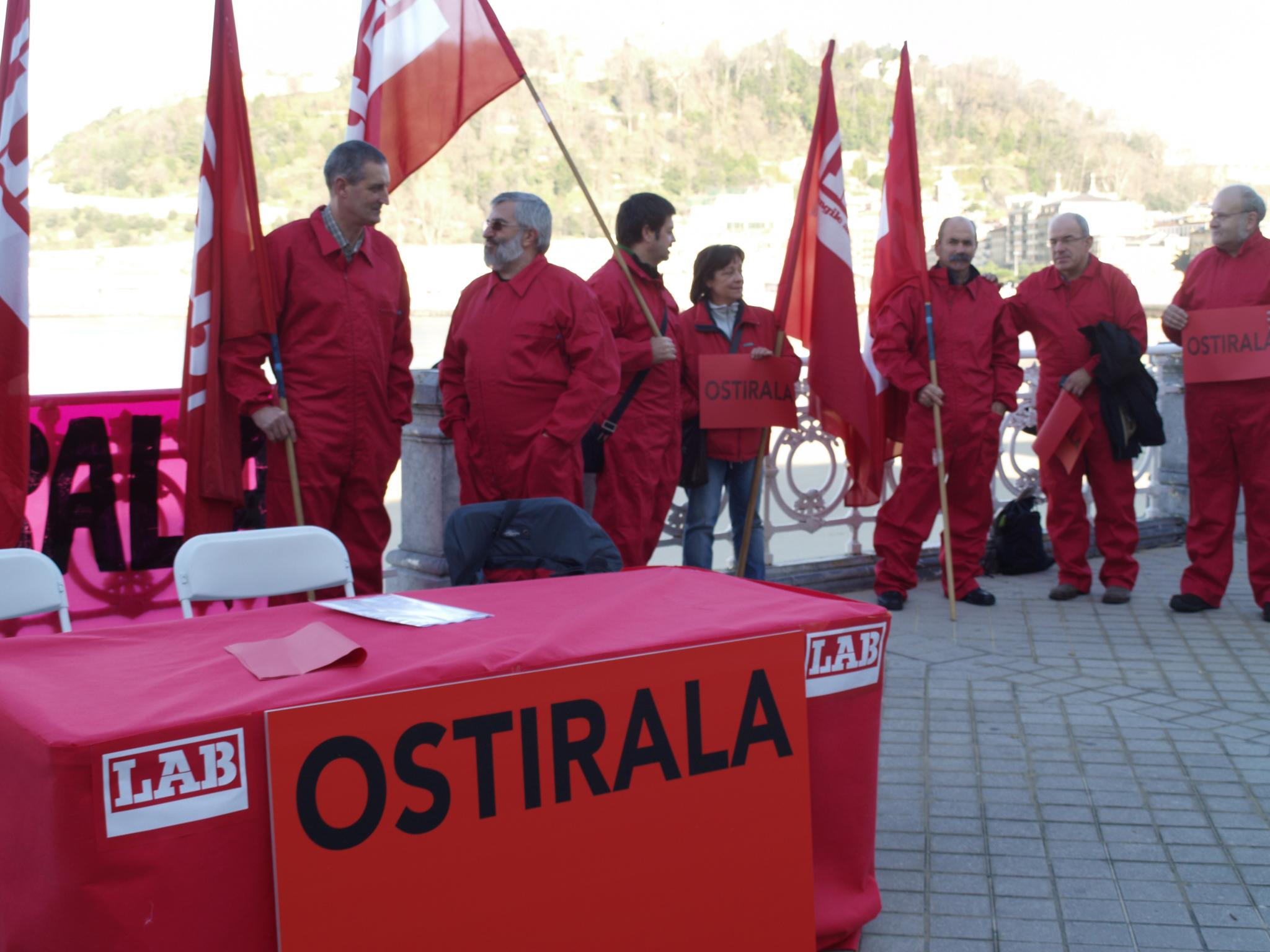 the men wearing red suits hold flags and signs