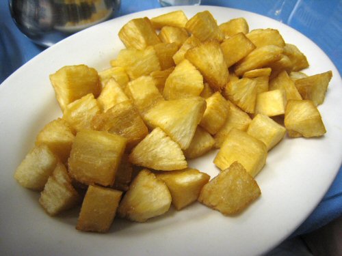 cut potatoes on a white plate with blue table cloth