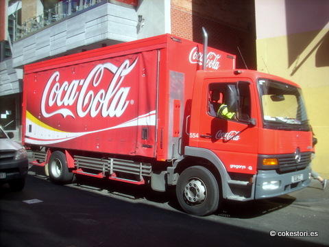 red coca - cola delivery truck on city street