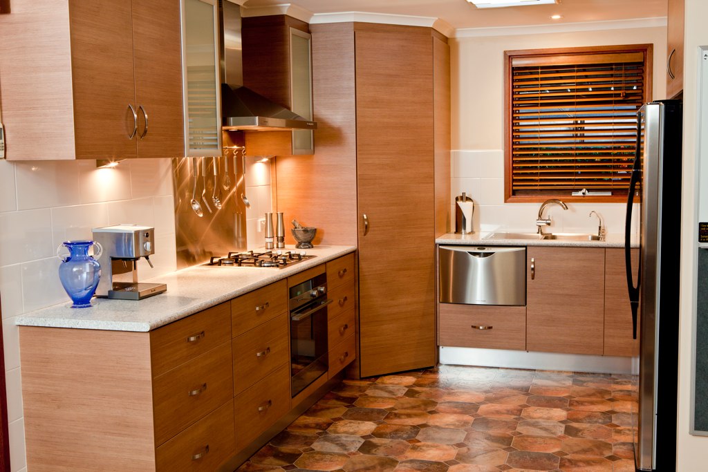 a brown kitchen with stainless steel appliances and wooden cabinetry