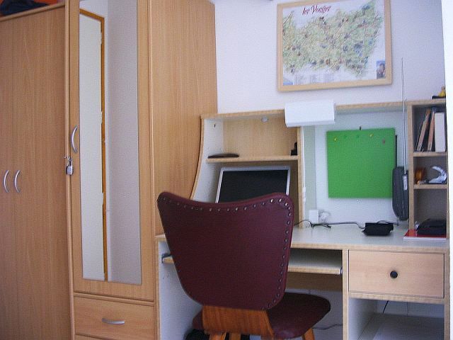 an office with a brown chair sitting next to a computer desk