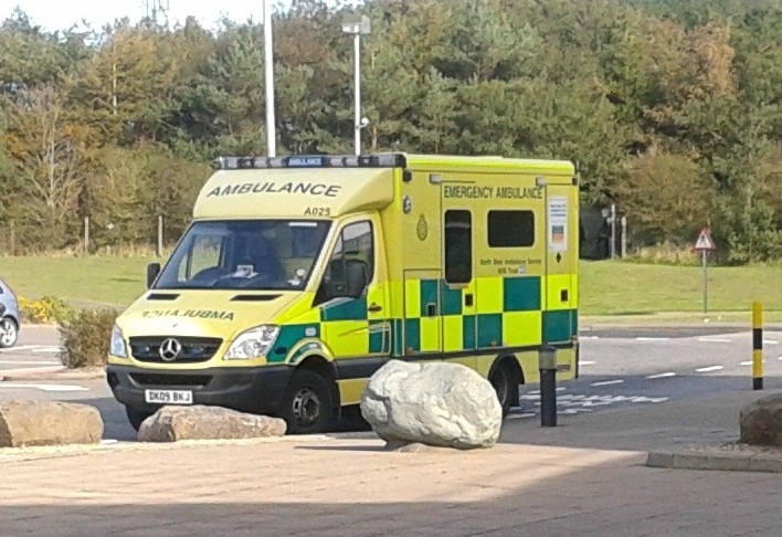 the ambulance is next to some large rocks