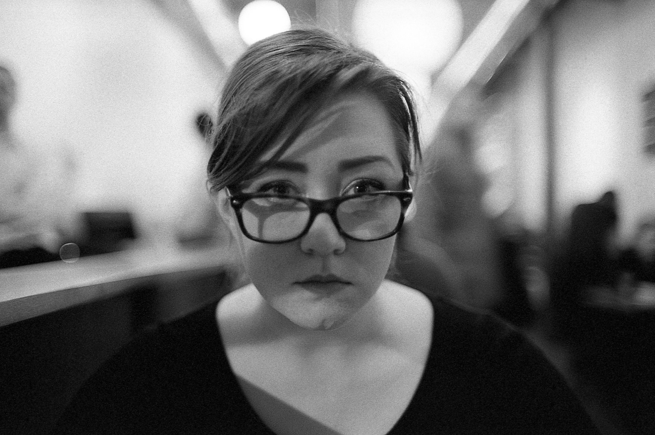 a black and white image of a woman wearing glasses