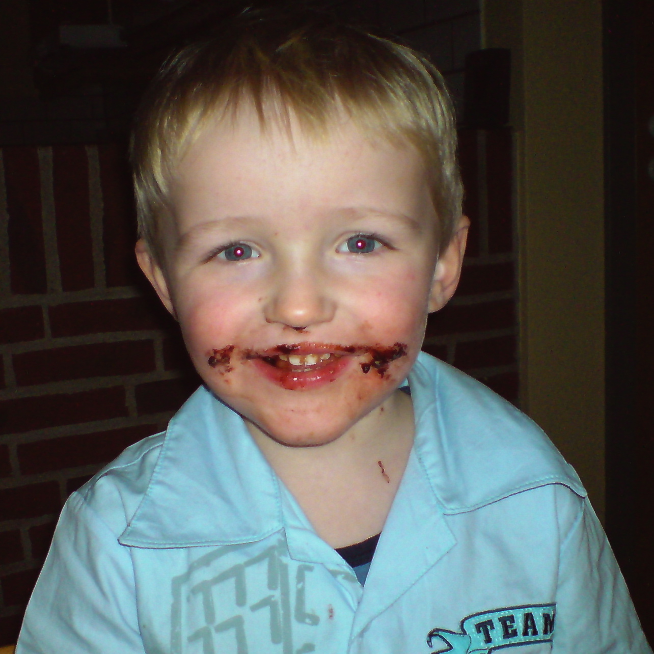 a small child is wearing chocolate while smiling