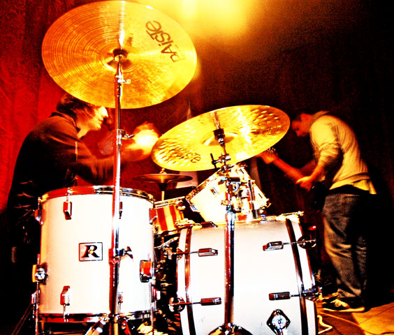 two men are playing drums in a band