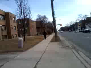 there is a person walking on the sidewalk near some buildings