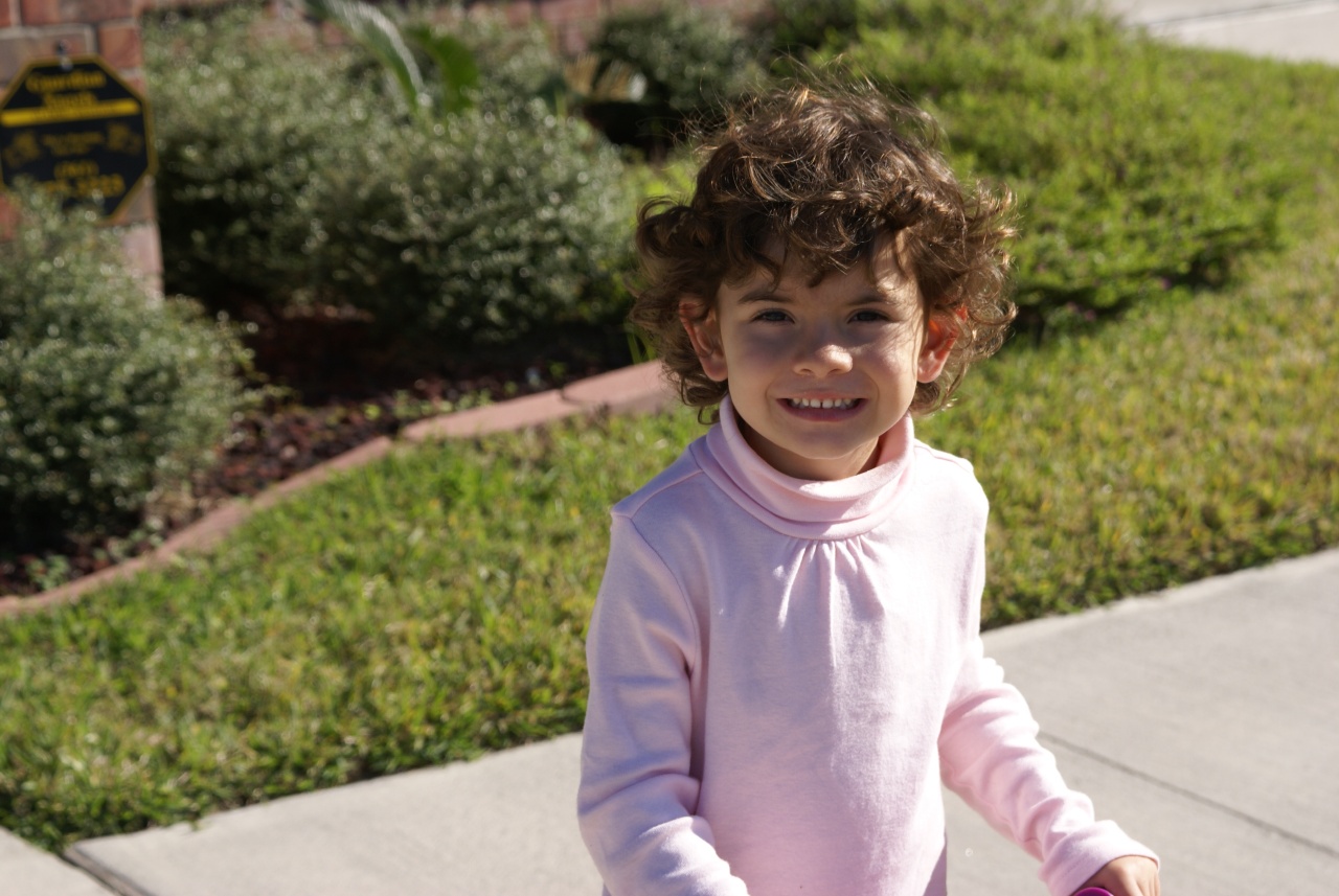 a little girl wearing pink smiling at the camera