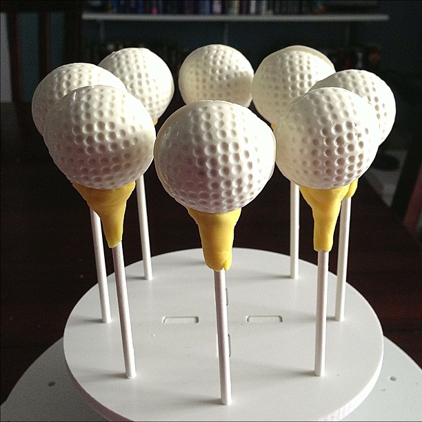 a display of seven yellow golf ball lollipops