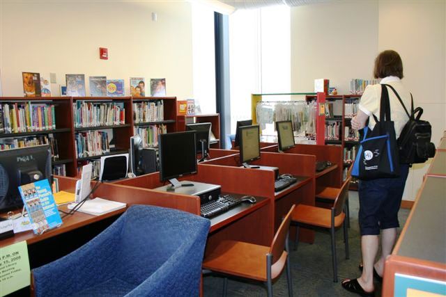a woman standing next to a book shelf filled with books
