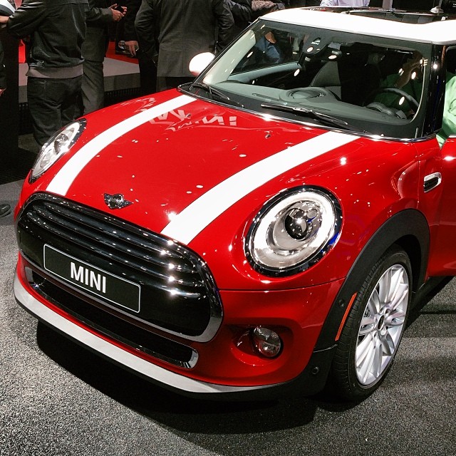 a small red and white mini cooper at a car show