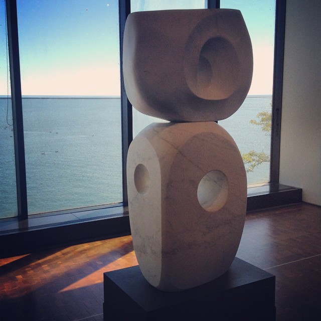 a sculpture on a pedestal looking out over the ocean