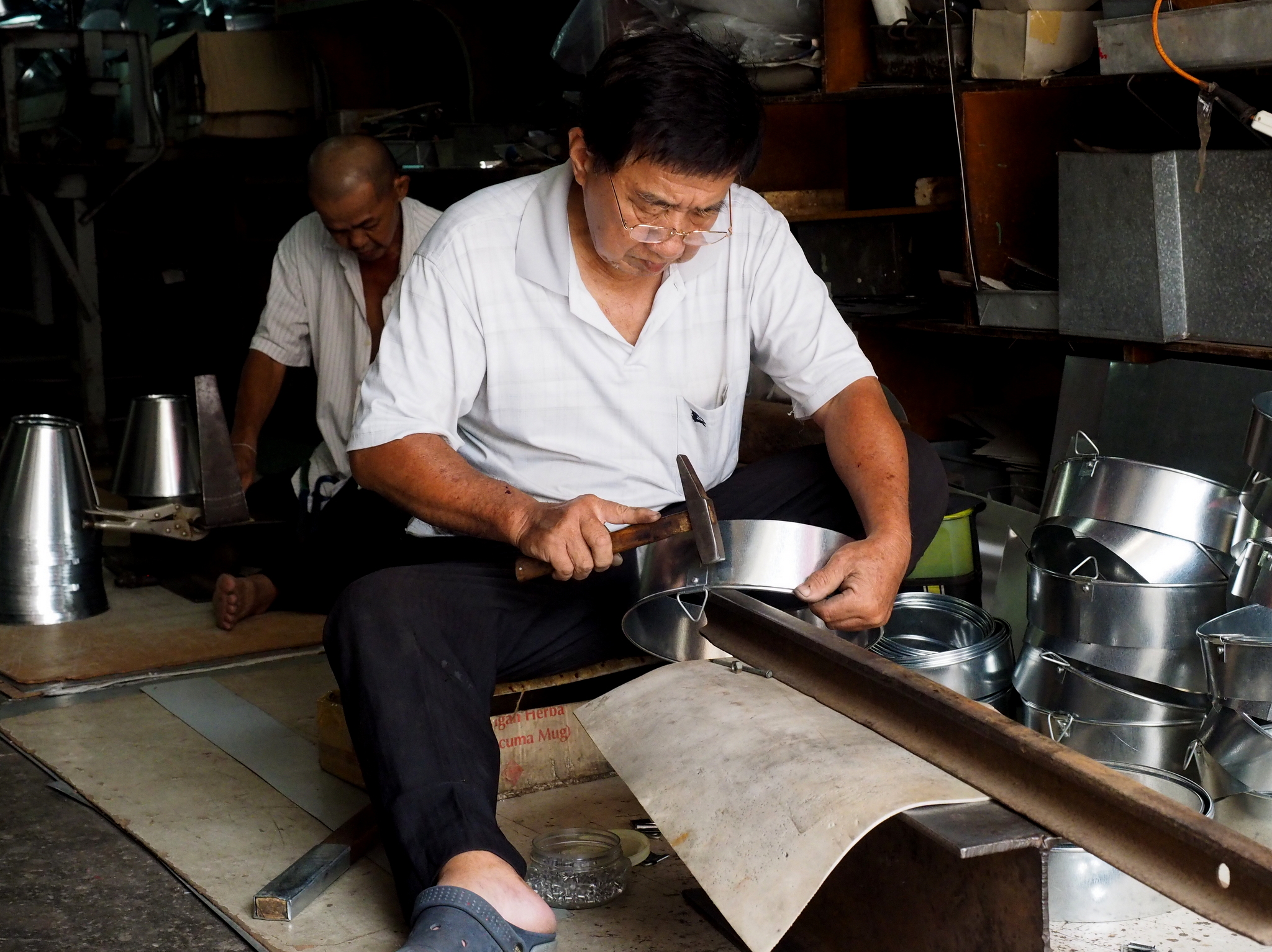 a man is sitting at the table in front of pots