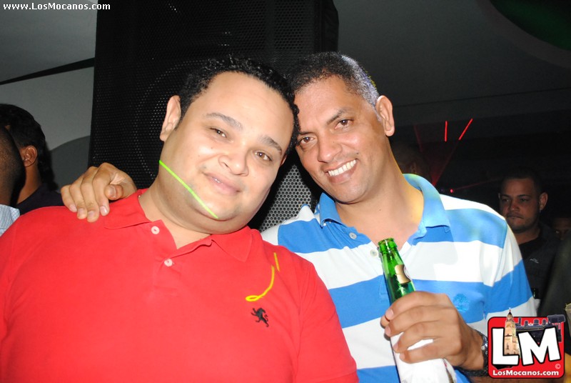 two men are holding beer bottles and posing for a picture