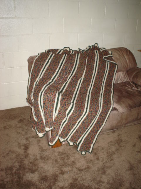 a blanket is folded over a leather couch