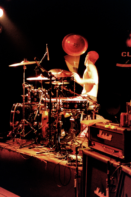 two men in the middle of playing drums on stage