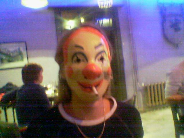 a woman in a clown mask smoking a cigarette