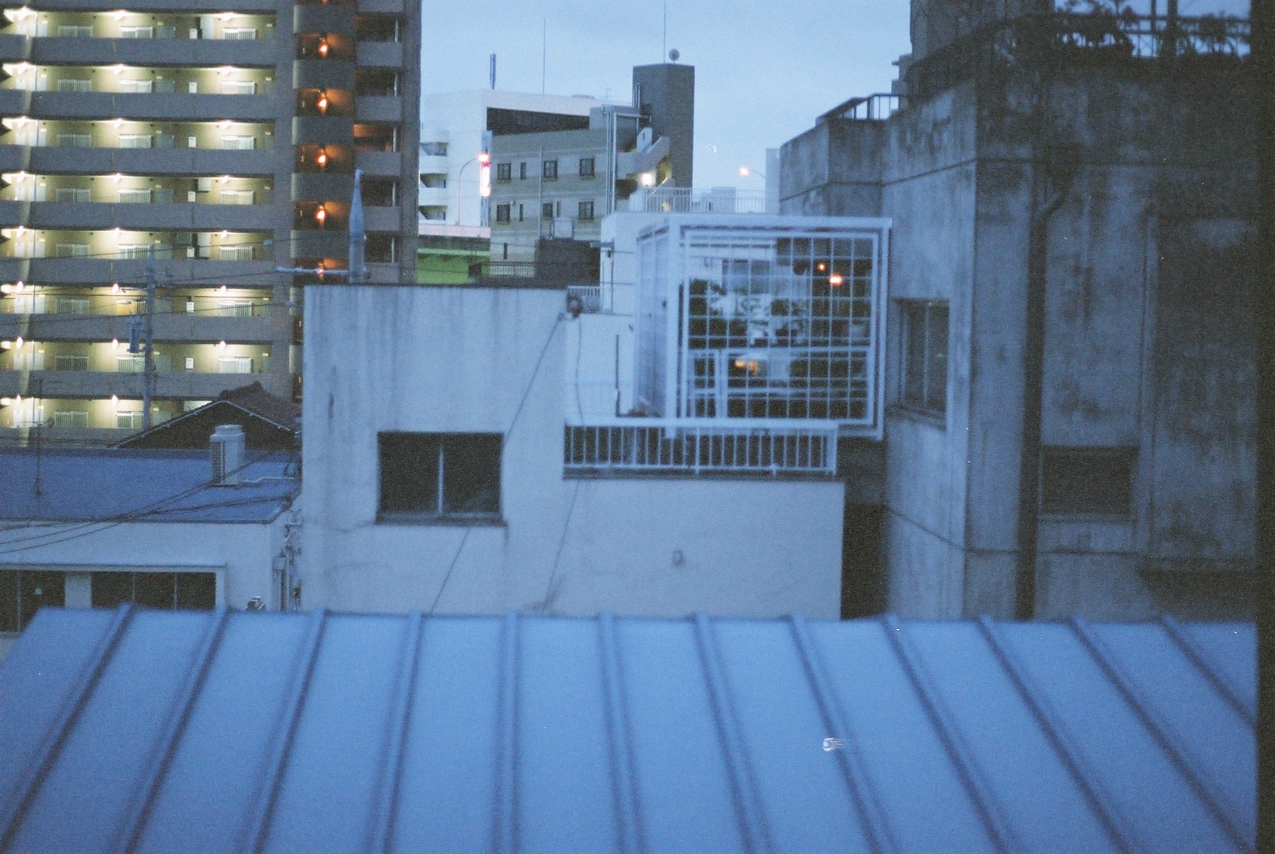 a skyline in the twilight with tall buildings and light from the windows