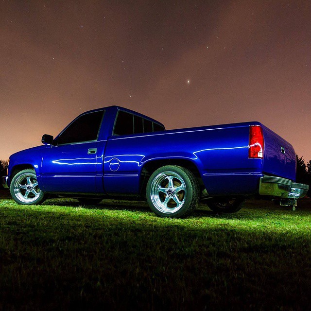 a truck is parked on the grass at night