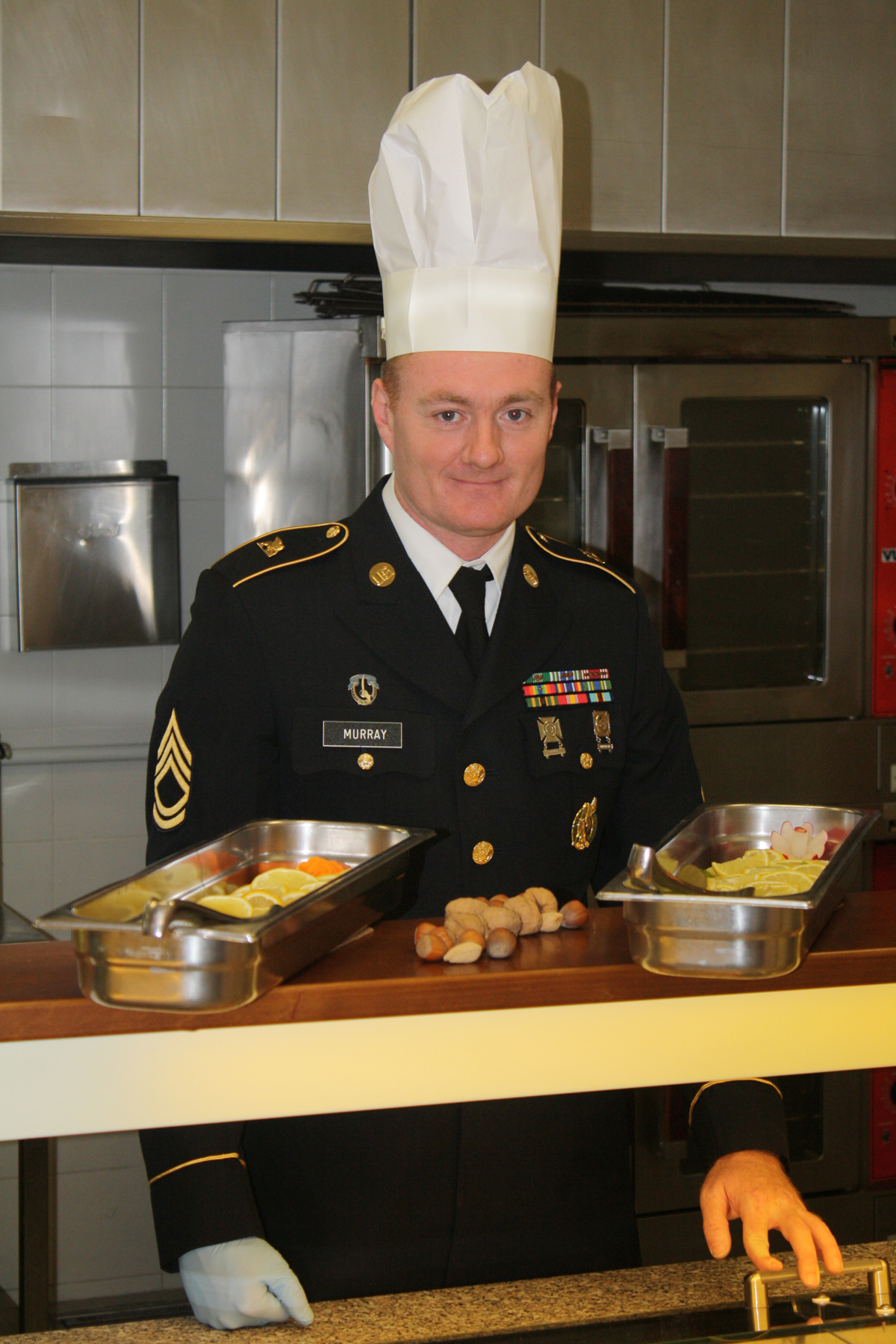 a man in a uniform at a counter with food in bowls