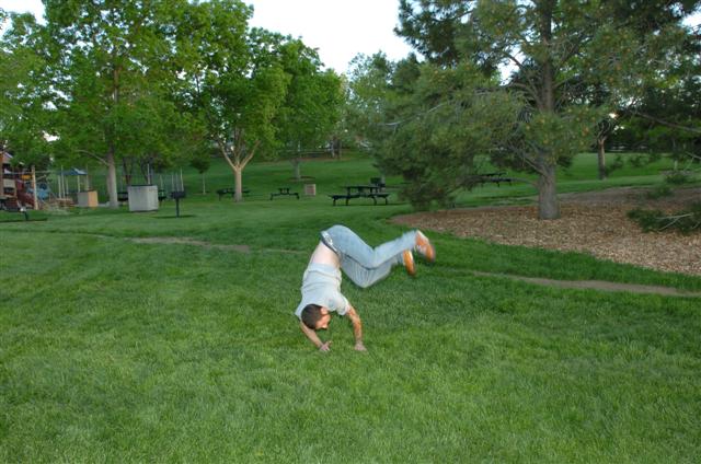 a person doing a handstand in a grassy field