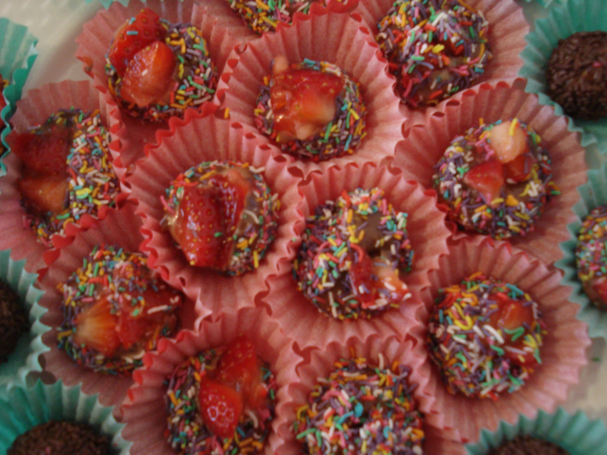 chocolate and strawberries covered with sugar in pink paper liners