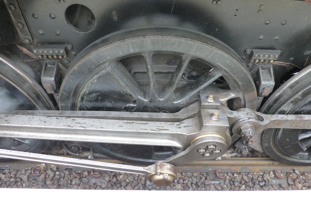 a close up of a train wheels with steam