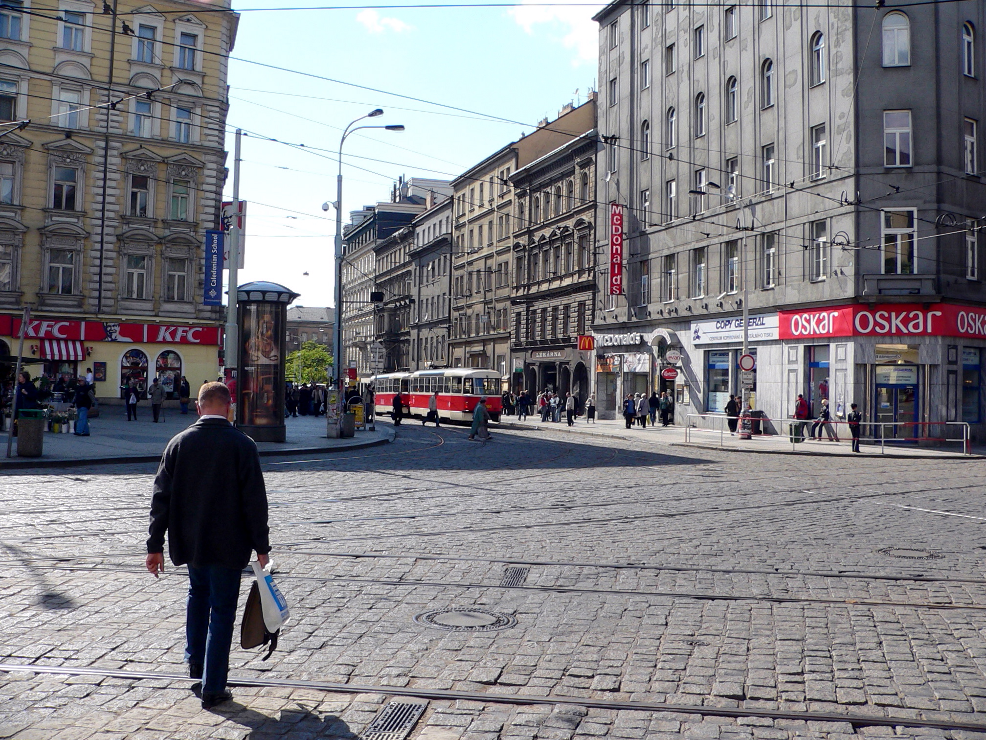 a man walking down a stone paved road