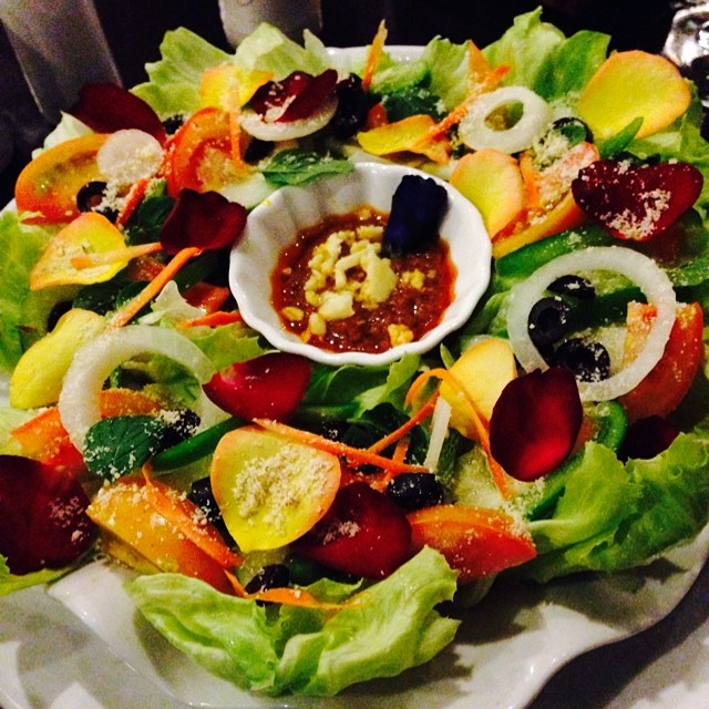 a salad on a plate covered in condiments