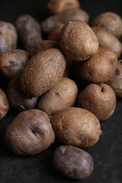 the potatoes are piled on the black table