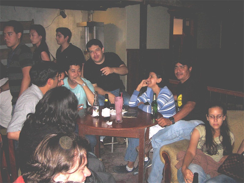 several people and two men sitting around a small table