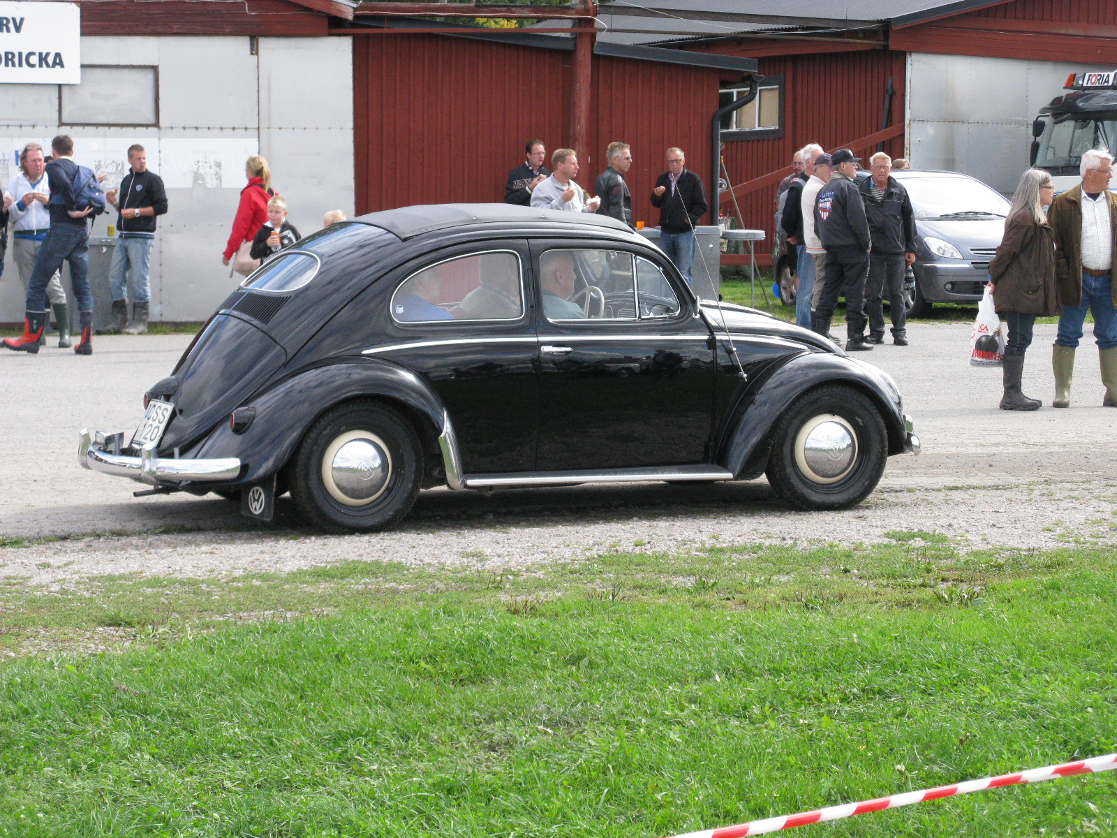 an old fashioned black beetle parked at a car show