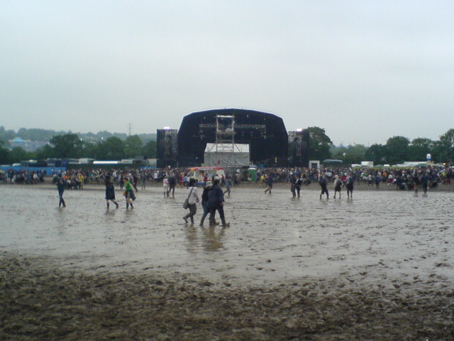 a large crowd in a large muddy field