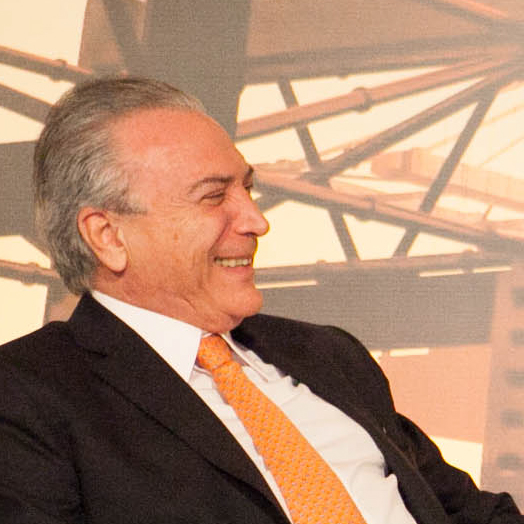 a man in suit and orange tie smiling