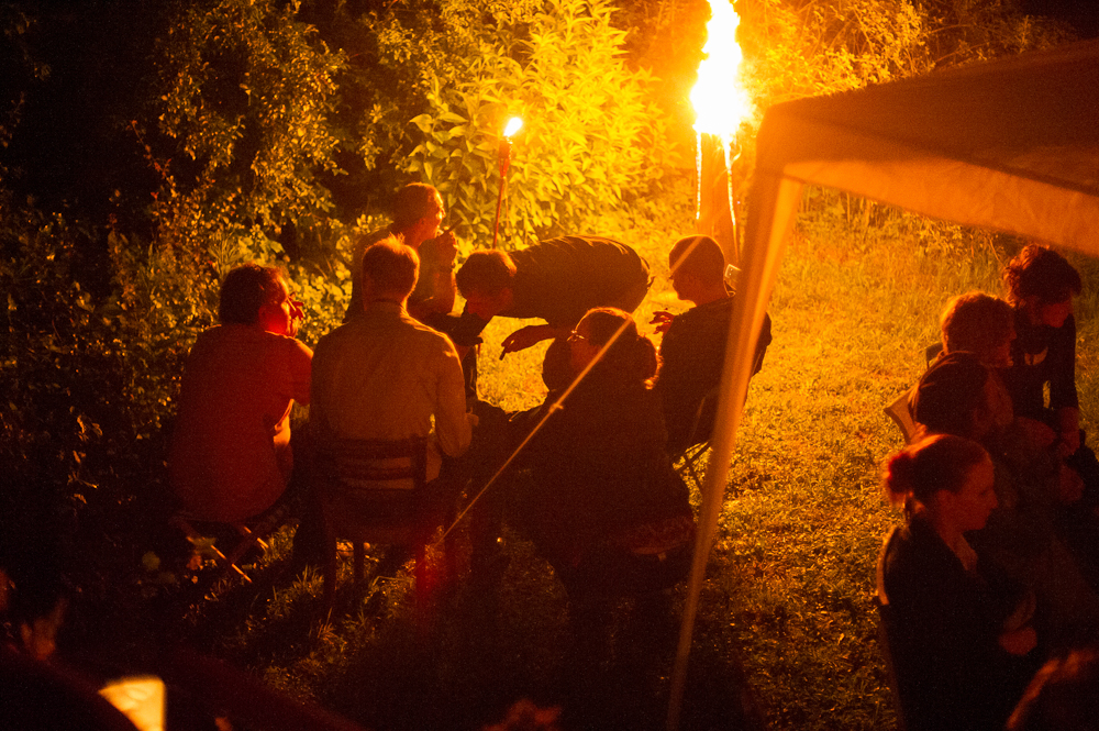 a large crowd gathers around the fire pit