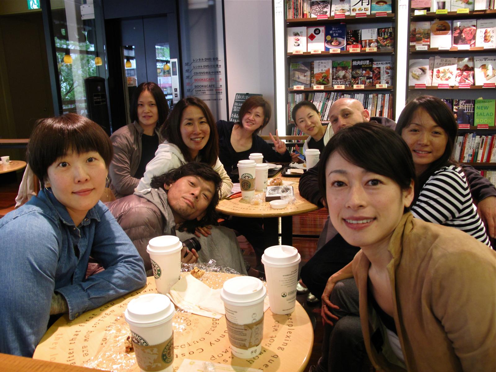 several people gathered at a cafe eating dessert