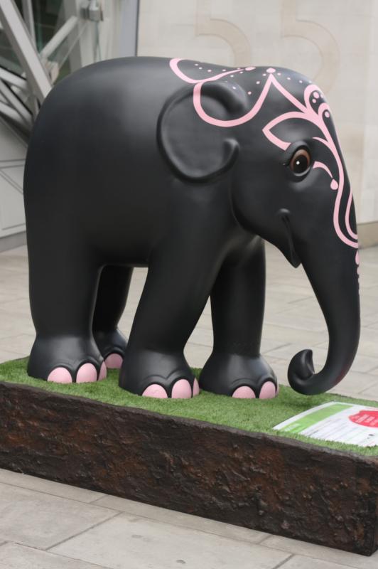 an elephant statue on a box with grass on the ground