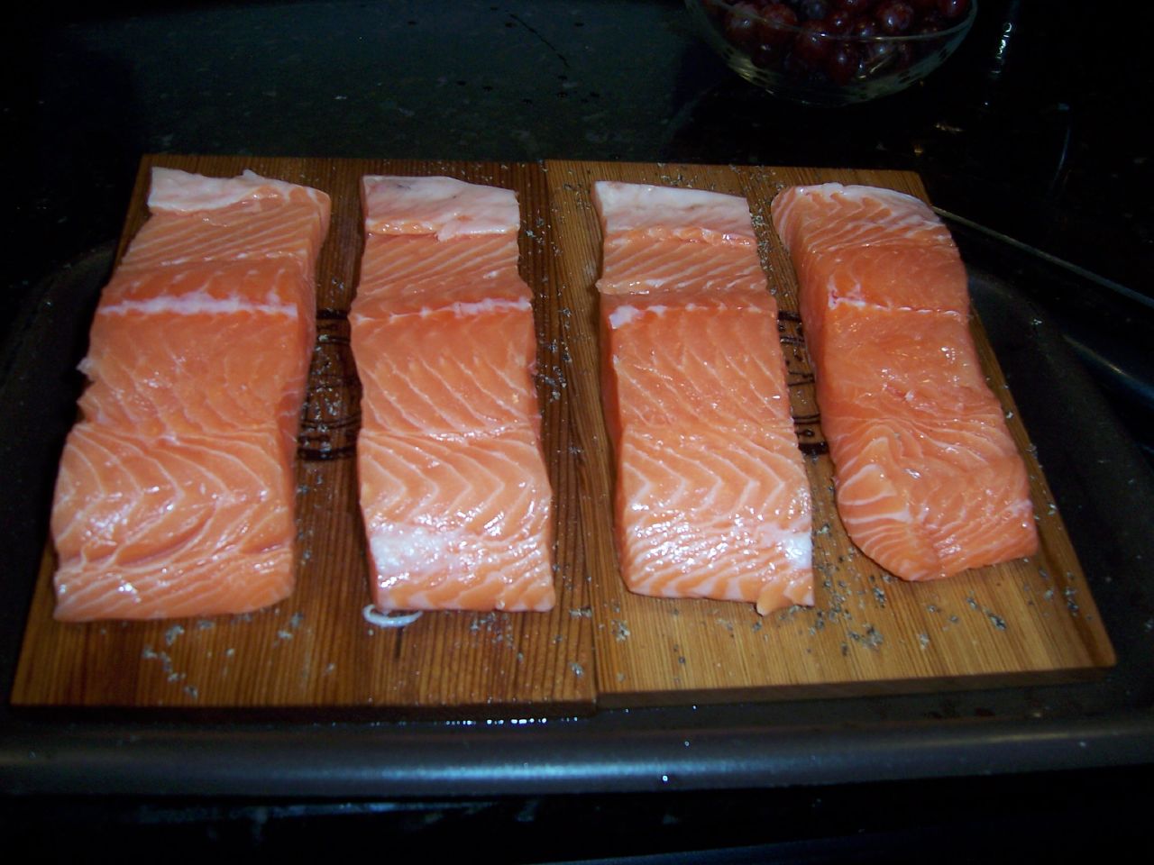 salmon sitting on top of a wooden  board