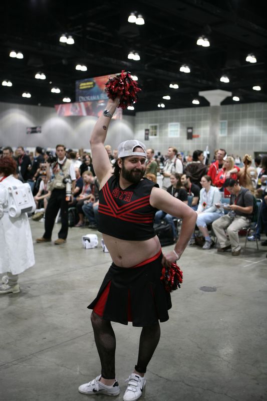 a man dressed in black and red with a tie and cheerleader outfit