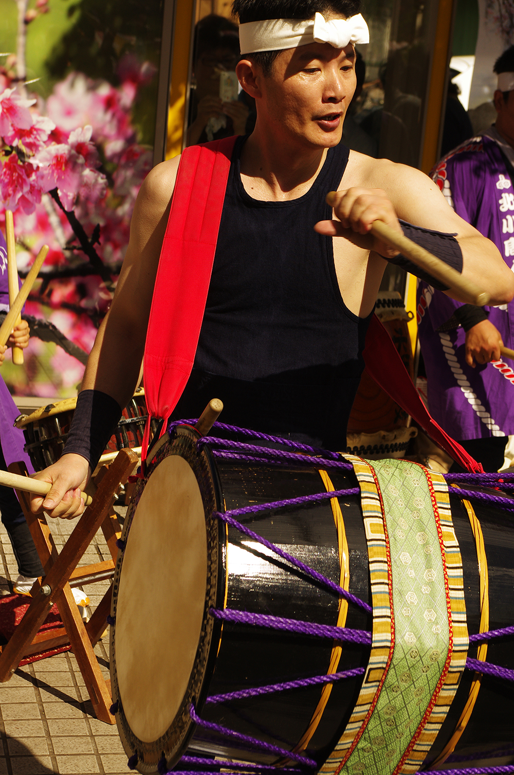 a group of asian people play on wooden drums