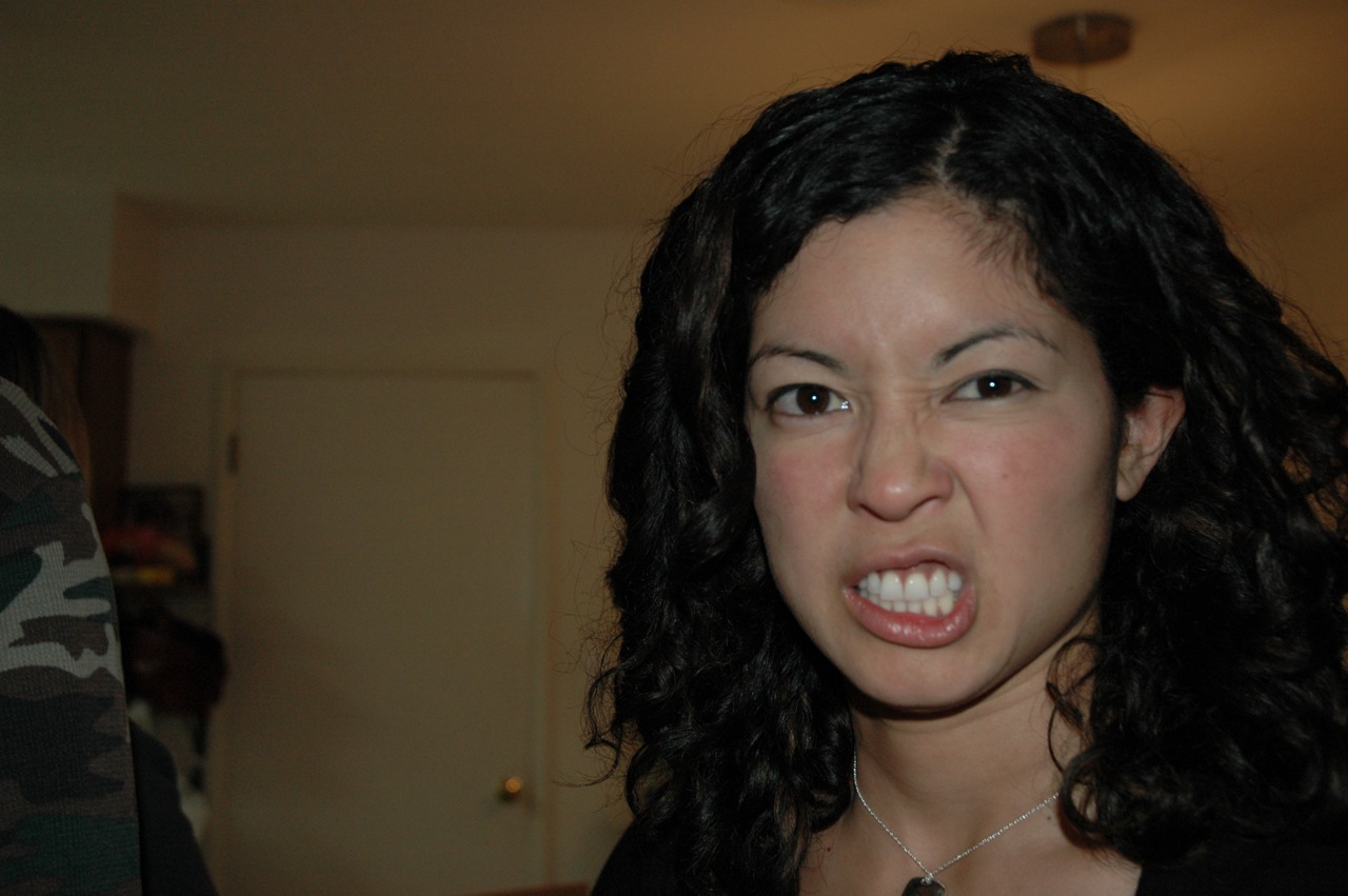 a woman standing and making a face with her tongue open