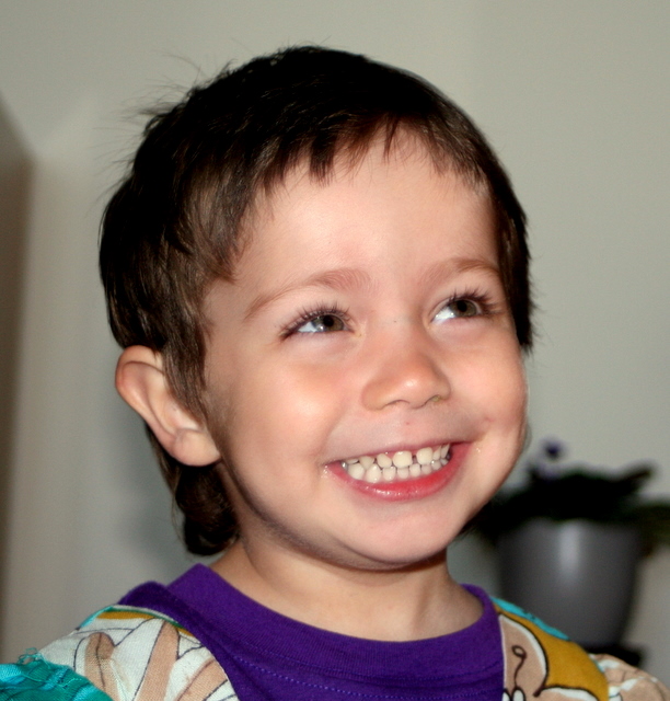 a young child is smiling with brown hair