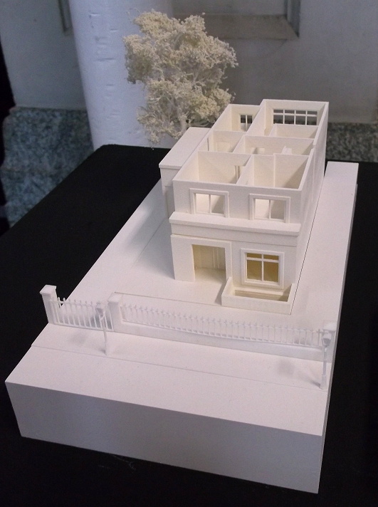 a model of a house sits on top of the table
