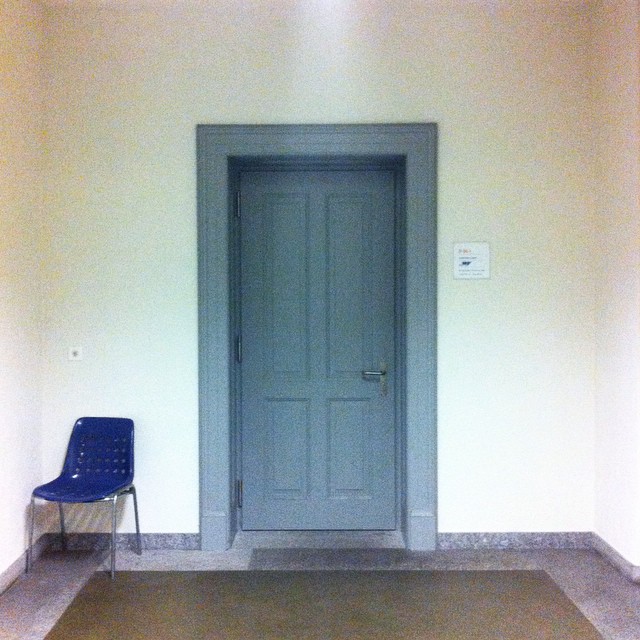 the blue chair sits alone in the hallway