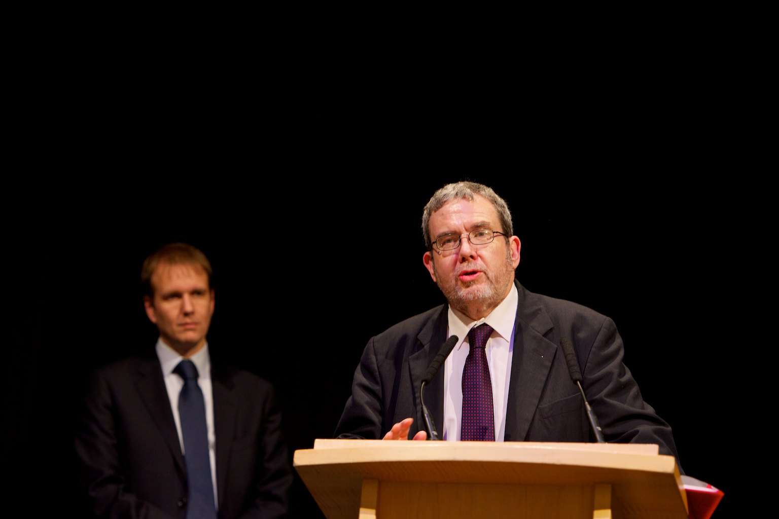 a man at a podium talking into a microphone