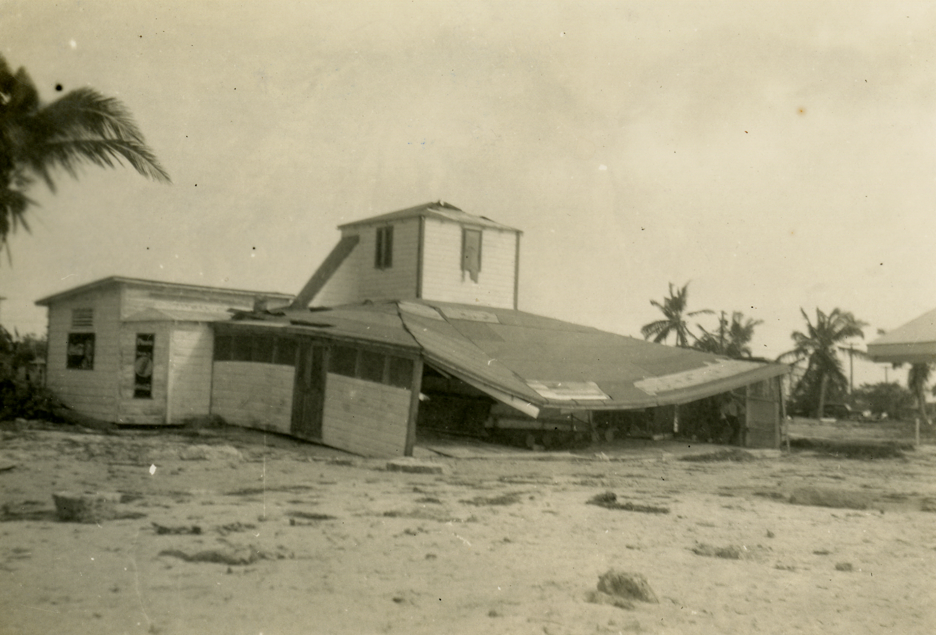 a beach area that has an overhanged house on top of it