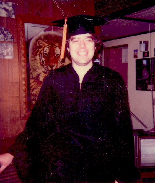 young man wearing graduation gown with hat and tassel