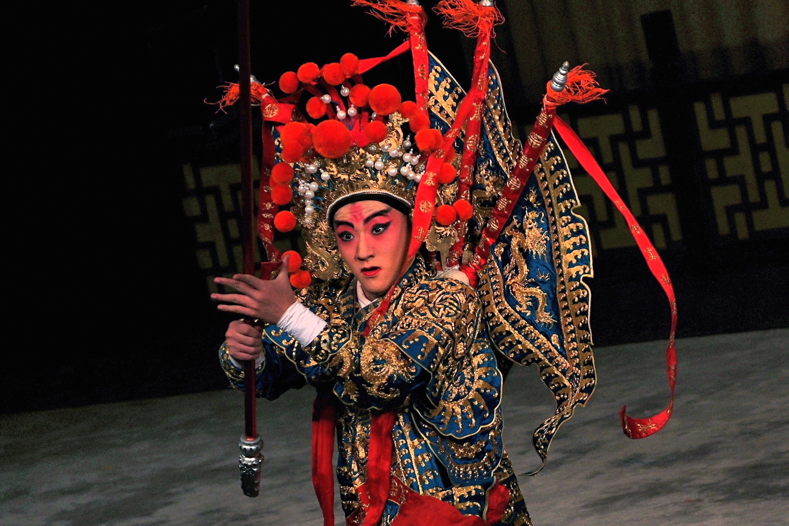 a person dressed in oriental costumes holding onto a pole